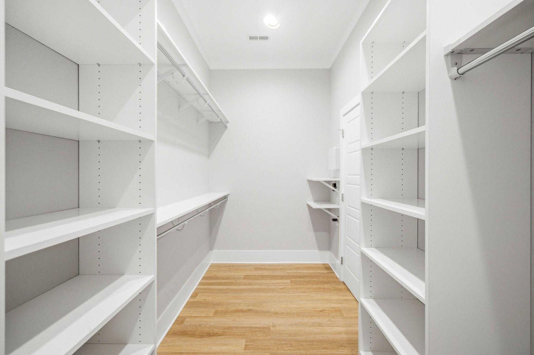 Large walk-in closet with extensive built-in shelving and hanging space.