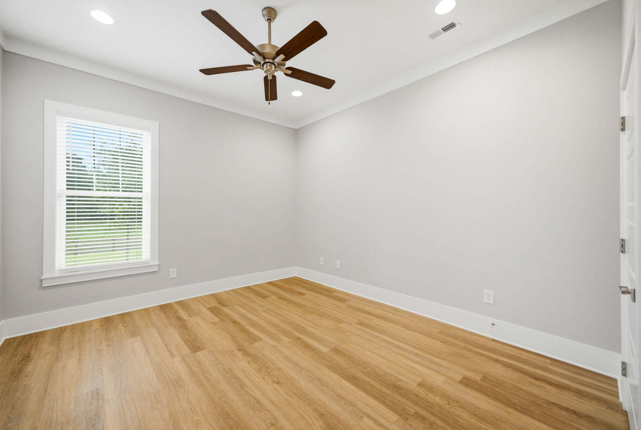 Comfortable second bedroom with ceiling fan and generous natural light.
