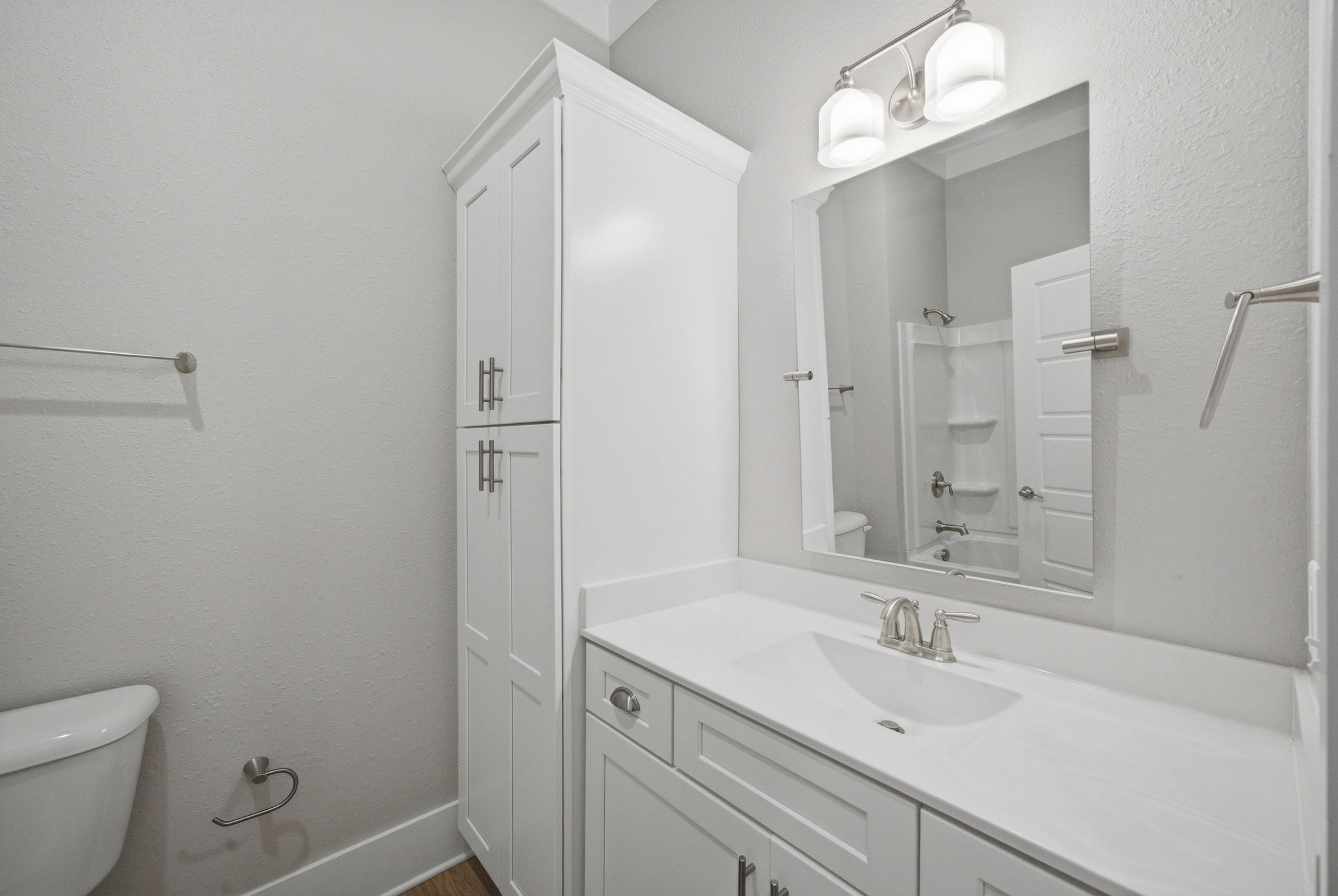 Full guest bath with generous vanity storage and tub/shower combination.