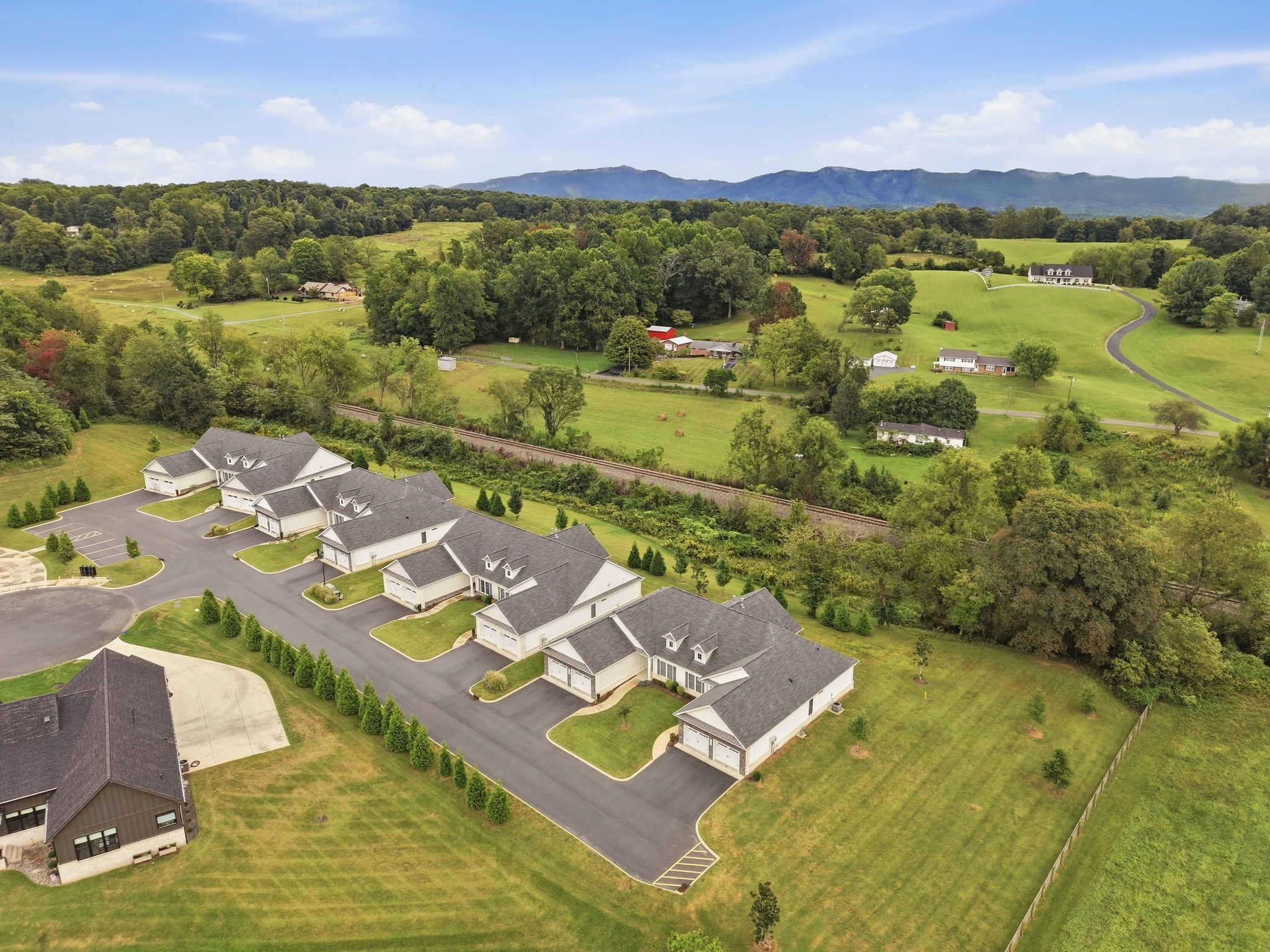 Quiet residential setting with open countryside and mountain views in the distance.