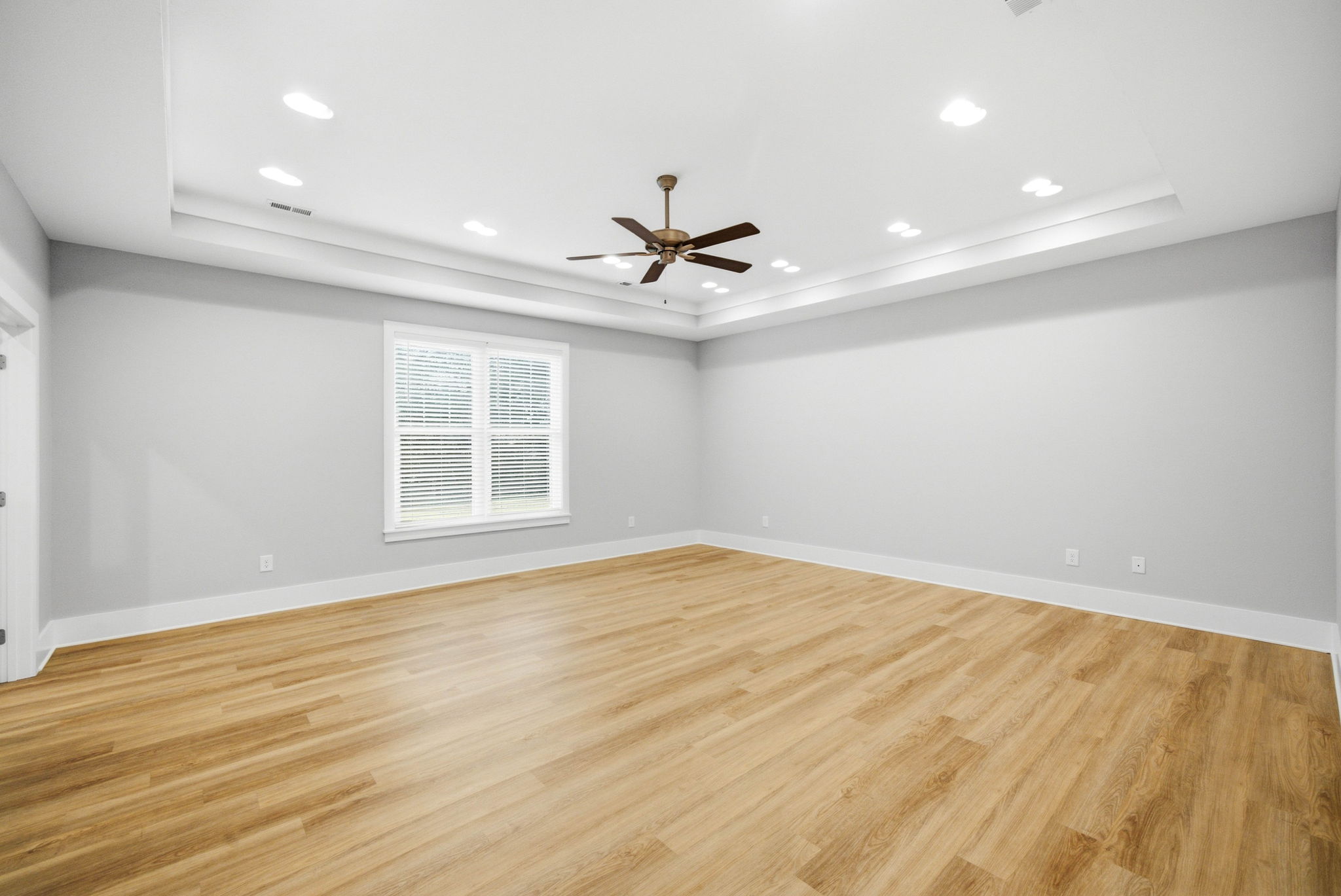 Oversized primary suite with tray ceiling and room for a sitting area or workspace.